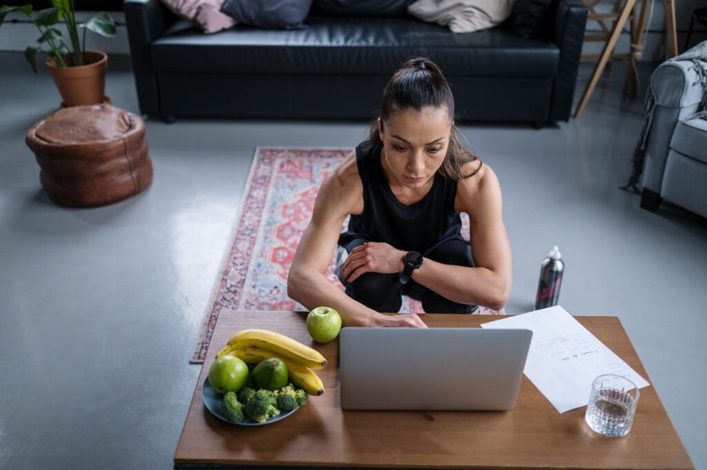 Fitnesstrainerin arbeitet am Laptop Eigene Website als FitnesstrainerIn – Darum lohnt sie sich